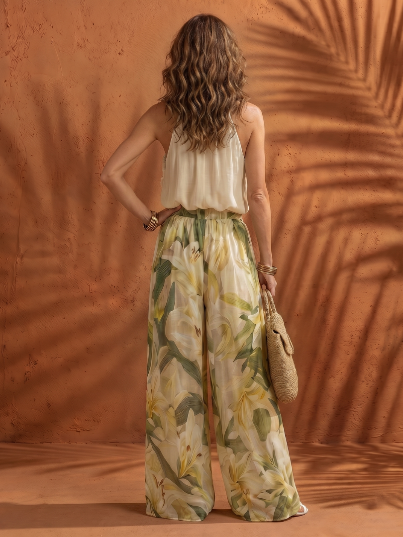 Solange floral halter neck blouse and wide-leg pants set by THE WHITMORE FAMILY, featuring a vibrant floral pattern and flowing fabric.