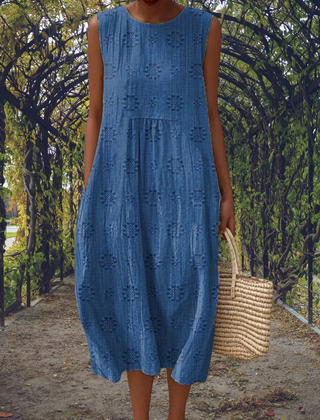 Elegant sleeveless Aikaterini dress by THE WHITMORE FAMILY in green with pockets, shown on a model.