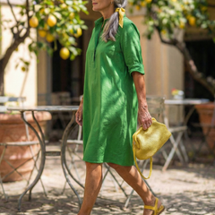 Green Giselle Morning Garden Dress by THE WHITMORE FAMILY, flowing fabric with floral pattern and elegant design.