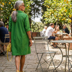 Green Giselle Morning Garden Dress by THE WHITMORE FAMILY, featuring floral patterns and flowing fabric.