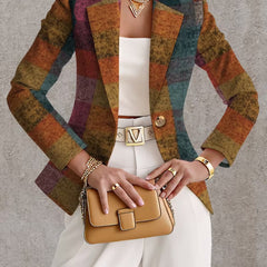 A woman wears the Amandine Autumn Plaid Blazer from THE WHITMORE FAMILY, featuring a stylish plaid pattern and tailored fit.