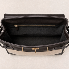 Interior view of THE WHITMORE FAMILY Delphine dark chocolate leather top handle bag showing compartments and material details.