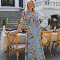 Elowen floral wrap V-neck maxi dress by THE WHITMORE FAMILY featuring a flowing skirt and vibrant floral pattern.