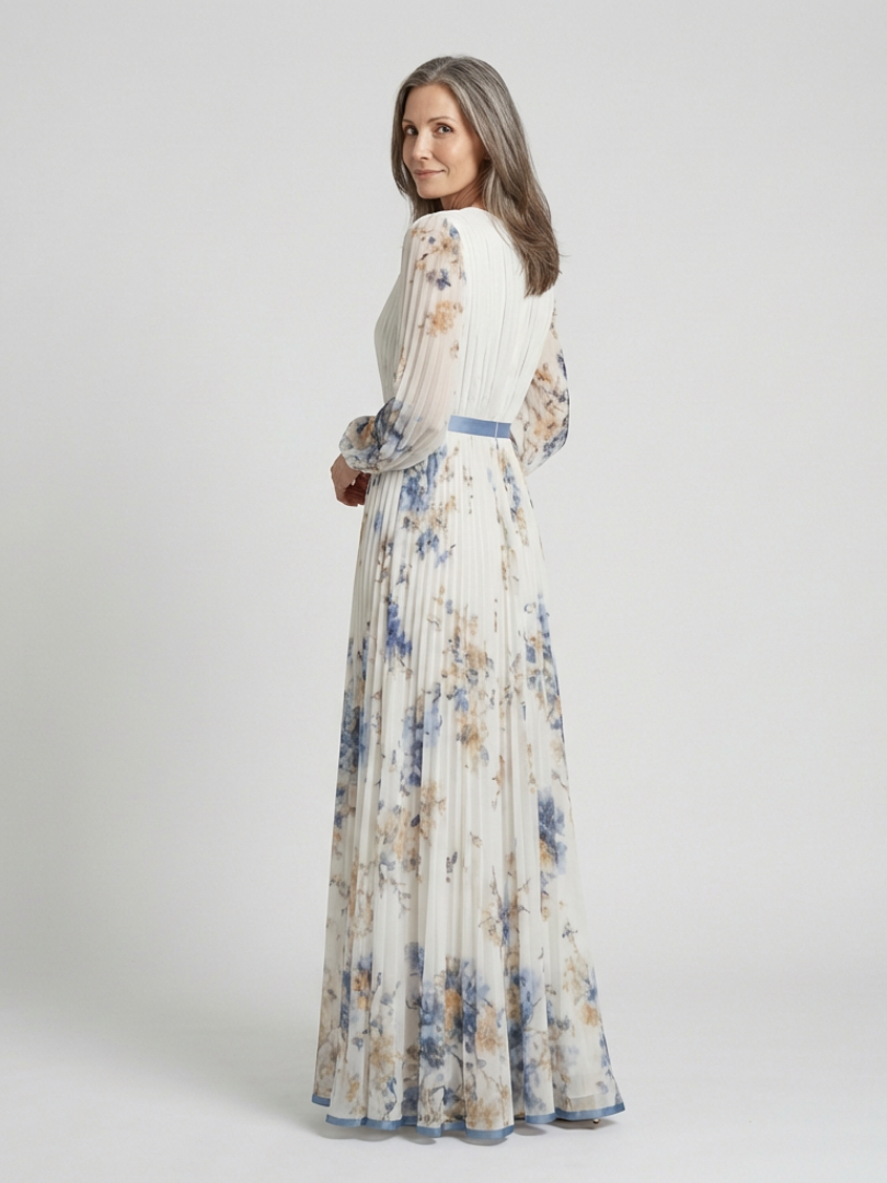 Long sleeve V-neck floral maxi dress by THE WHITMORE FAMILY, featuring a flowing silhouette and vibrant floral pattern.