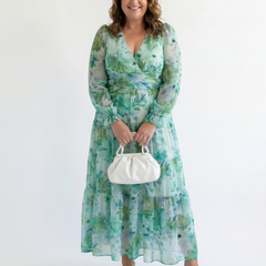 Long sleeve floral maxi dress by THE WHITMORE FAMILY, flowing fabric with a colorful floral pattern and fitted waist.