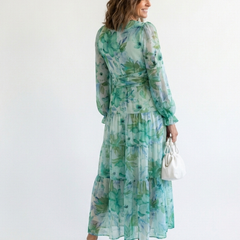 Long sleeve floral maxi dress by THE WHITMORE FAMILY with a flowing silhouette and vibrant floral patterns.