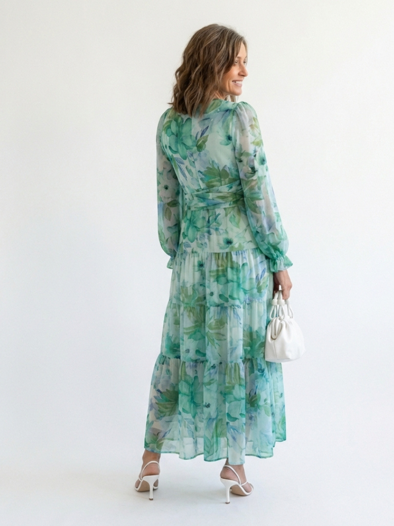 Long sleeve floral maxi dress by THE WHITMORE FAMILY with a flowing silhouette and vibrant floral patterns.