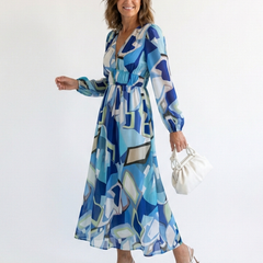 Long sleeve floral maxi dress by THE WHITMORE FAMILY featuring a flowing silhouette and vibrant floral pattern.