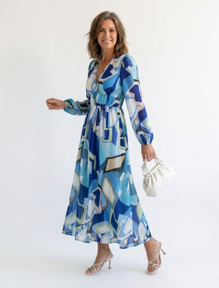 Long sleeve floral maxi dress by THE WHITMORE FAMILY featuring a flowing silhouette and vibrant floral pattern.