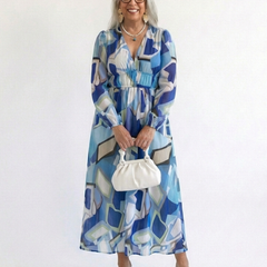 Long sleeve floral maxi dress by THE WHITMORE FAMILY featuring a flowing fabric and vibrant floral pattern.