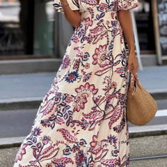 Purple floral print maxi dress with puff sleeves from THE WHITMORE FAMILY's Joan collection, shown on a model.