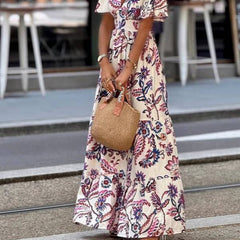 Purple floral print maxi dress with puff sleeves, Joan by THE WHITMORE FAMILY, shown with a flowing, elegant design.