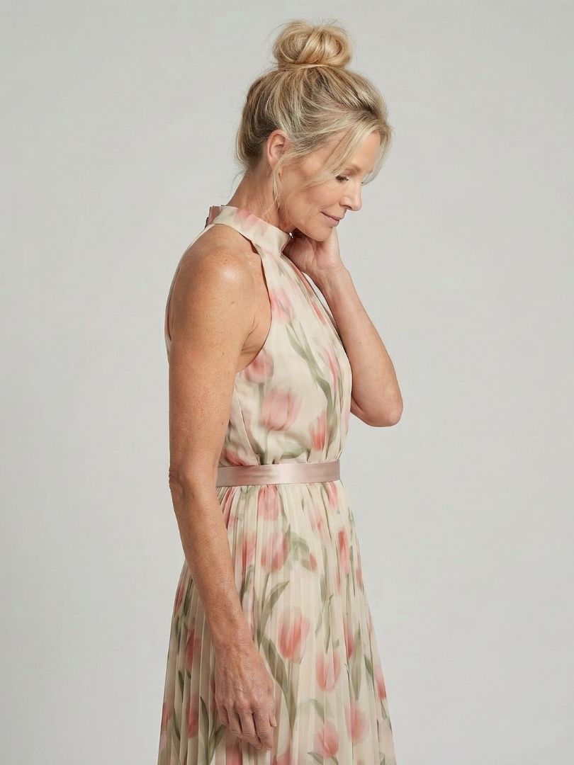 Aurelle floral midi dress by THE WHITMORE FAMILY featuring a halter neck and vibrant floral pattern on flowing fabric.