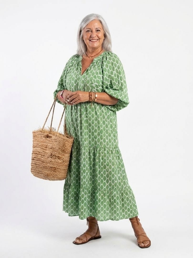 A model wearing the Apolline three-quarter sleeve V-neck patterned midi dress by THE WHITMORE FAMILY, showcasing its stylish design.