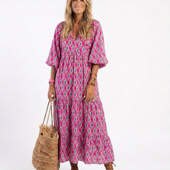 A patterned midi dress with three-quarter sleeves and a v-neck neckline by THE WHITMORE FAMILY, styled for spring or casual wear.