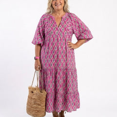 A woman wearing the Apolline midi dress with three-quarter sleeves, V-neck, and a patterned design suitable for spring or Easter occasions.