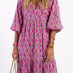 A model wearing the Apolline three-quarter sleeve V-neck patterned midi dress by THE WHITMORE FAMILY, showcasing its stylish design.