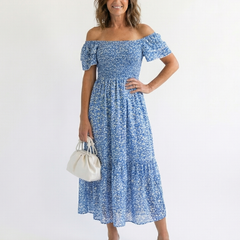 Odette off-shoulder floral smocked midi dress by THE WHITMORE FAMILY, featuring a flowy silhouette and vibrant floral print.