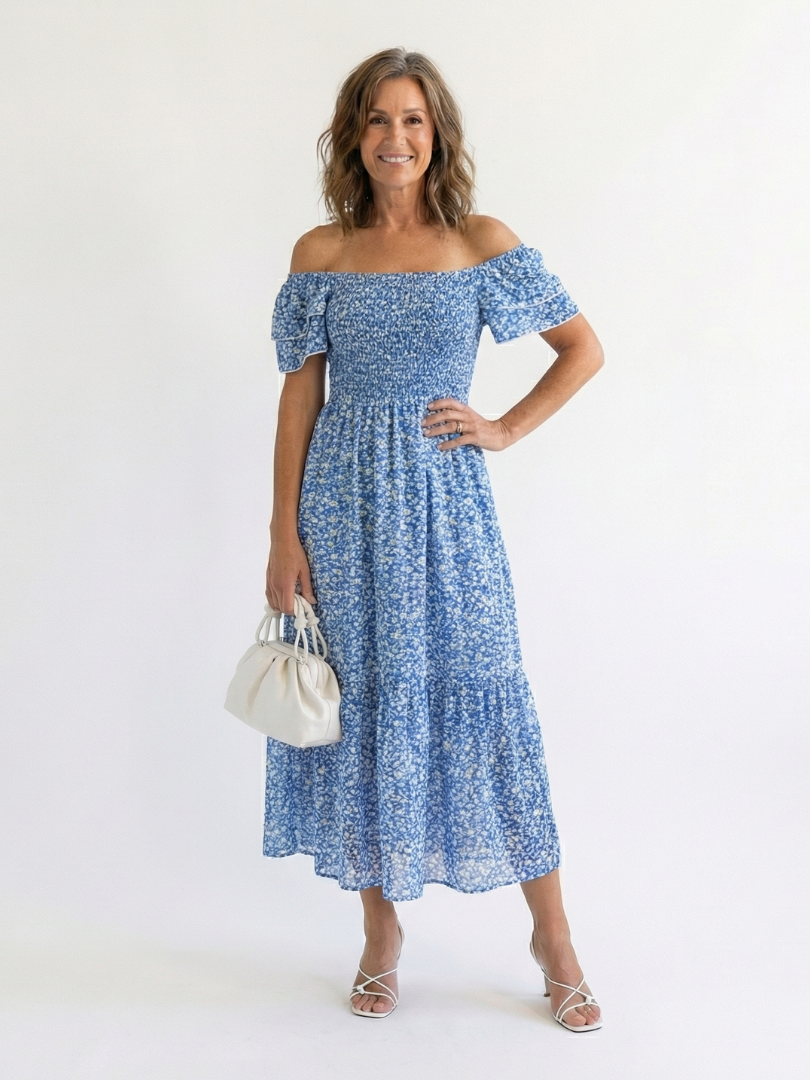 Odette off-shoulder floral smocked midi dress by THE WHITMORE FAMILY, featuring a flowy silhouette and vibrant floral print.