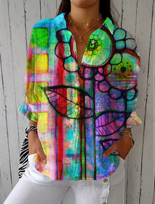 Multicolor Bianca™ Artistic Bloom Blouse by THE WHITMORE FAMILY displayed on a hanger with floral pattern and lightweight fabric.