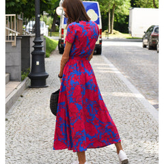 Multicolored floral V-neck dress by THE WHITMORE FAMILY, styled with a fitted waist and flowing fabric for a chic, feminine look.