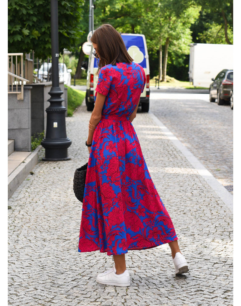 Multicolored floral V-neck dress by THE WHITMORE FAMILY, styled with a fitted waist and flowing fabric for a chic, feminine look.