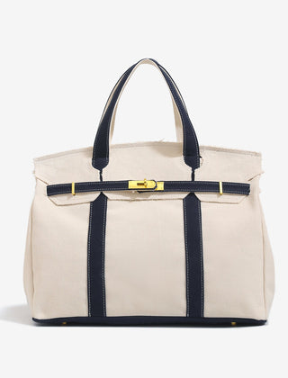 The Camille Boat Tote by THE WHITMORE FAMILY, a stylish canvas tote with leather handles and spacious interior, displayed on a white background.