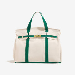 The Camille Boat Tote by THE WHITMORE FAMILY in natural woven straw with leather handles and spacious interior.