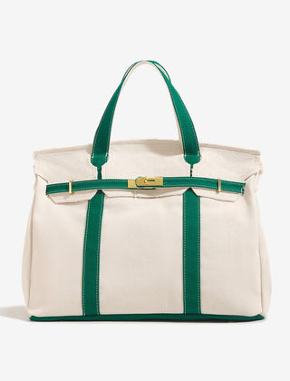 The Camille Boat Tote by THE WHITMORE FAMILY in natural woven straw with leather handles and spacious interior.