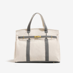 The Camille Boat Tote by THE WHITMORE FAMILY in natural woven material with leather handles and spacious interior.