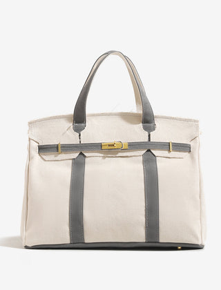 The Camille Boat Tote by THE WHITMORE FAMILY in natural woven material with leather handles and spacious interior.