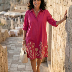 Pink Damaris Slow Day Dress by THE WHITMORE FAMILY displayed on a hanger with a soft fabric texture and casual style.