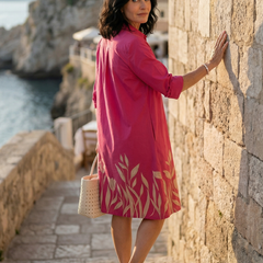 Pink Damaris Slow Day Dress by THE WHITMORE FAMILY, featuring lightweight fabric and a relaxed fit, displayed on a hanger.