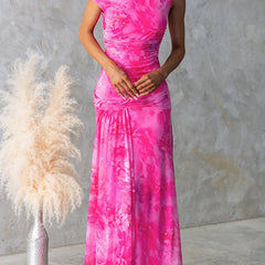 Elegant pink printed maxi dress by THE WHITMORE FAMILY featuring a flowing silhouette and intricate floral patterns.