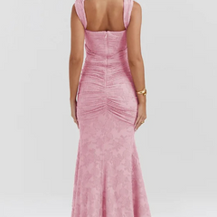 Elegant pink wedding dress by THE WHITMORE FAMILY featuring intricate lace details and a flowing train.