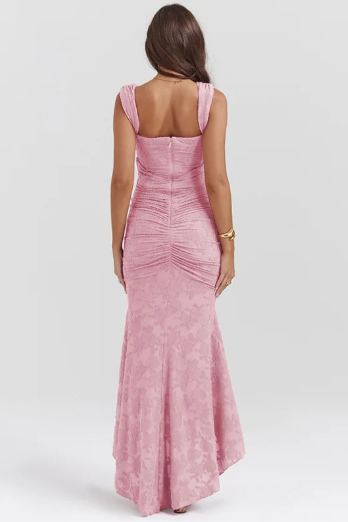 Elegant pink wedding dress by THE WHITMORE FAMILY featuring intricate lace details and a flowing train.