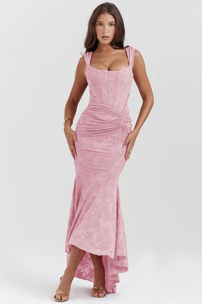 Elegant pink wedding dress named Gloria by THE WHITMORE FAMILY, featuring intricate lace details and a flowing train.