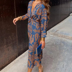Elegant Dineke floral print dress by THE WHITMORE FAMILY, shown in deep red with intricate floral patterns.