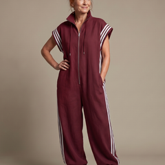 Red Lark Zip Front Stripe Panel Jumpsuit by THE WHITMORE FAMILY, featuring a front zipper and bold stripe details.