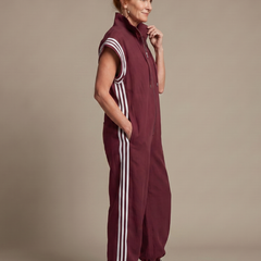 Red Lark Zip Front Stripe Panel Jumpsuit by THE WHITMORE FAMILY, showing the front view with stripe panels and zip closure.