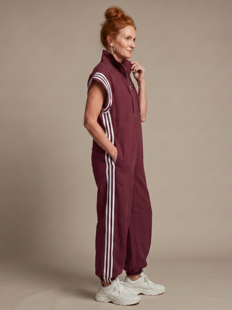 Red Lark Zip Front Stripe Panel Jumpsuit by THE WHITMORE FAMILY, showing the front view with stripe panels and zip closure.