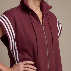 Red Lark zip-front stripe panel jumpsuit by THE WHITMORE FAMILY, showcasing a stylish, fitted design with a front zipper and bold stripe details.