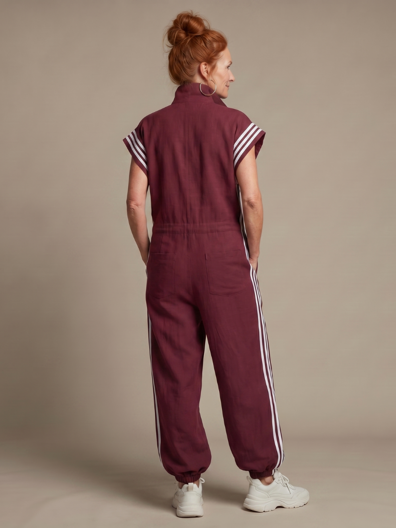 Red Lark zip front stripe panel jumpsuit by THE WHITMORE FAMILY, featuring a stylish front zipper and bold stripe design.