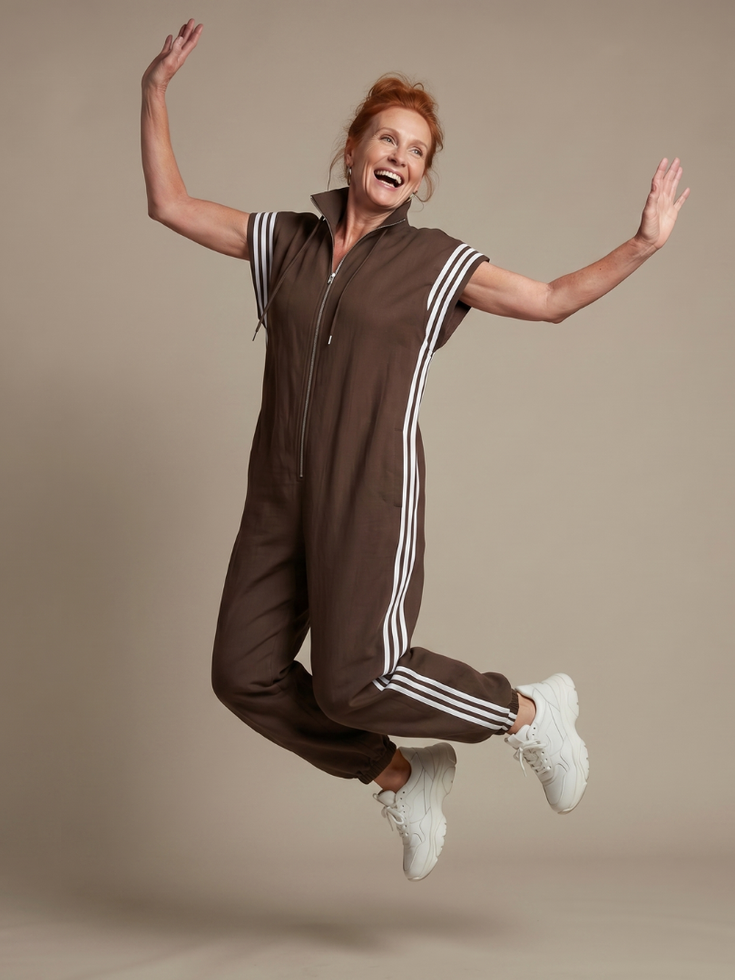 Red Lark Zip Front Stripe Panel Jumpsuit by THE WHITMORE FAMILY, featuring a fitted design and bold stripe details.