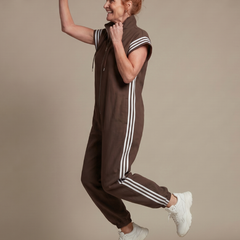 Red Lark zip front stripe panel jumpsuit by THE WHITMORE FAMILY, featuring a fitted silhouette and bold stripe details.