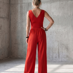 Vincenza wide-leg jumpsuit by THE WHITMORE FAMILY featuring a deep V waist design and vibrant red color.
