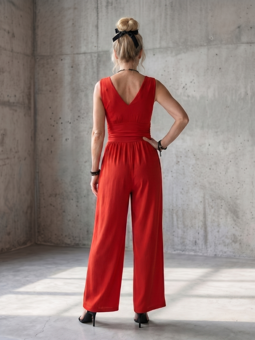 Vincenza wide-leg jumpsuit by THE WHITMORE FAMILY featuring a deep V waist design and vibrant red color.