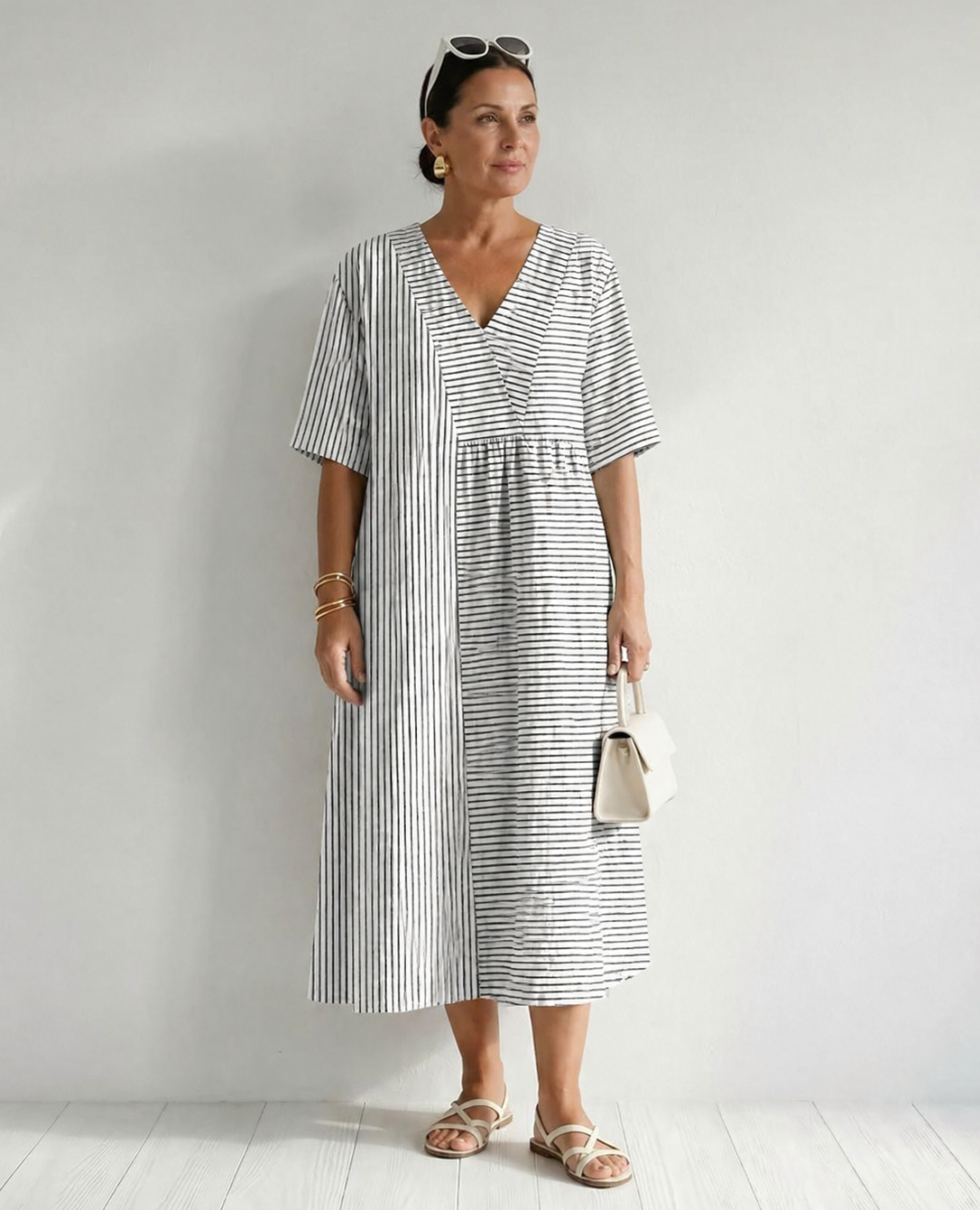 Isa vintage striped dress by THE WHITMORE FAMILY displayed on a hanger with a classic pattern and soft fabric.