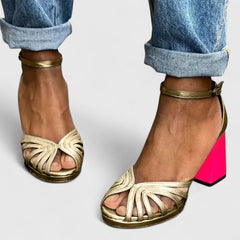 Gold Noelyrah Sandaal heels by THE WHITMORE FAMILY featuring elegant, sophisticated design with a sleek heel and stylish straps.