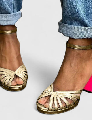 Gold Noelyrah Sandaal heels by THE WHITMORE FAMILY featuring elegant, sophisticated design with a sleek heel and stylish straps.
